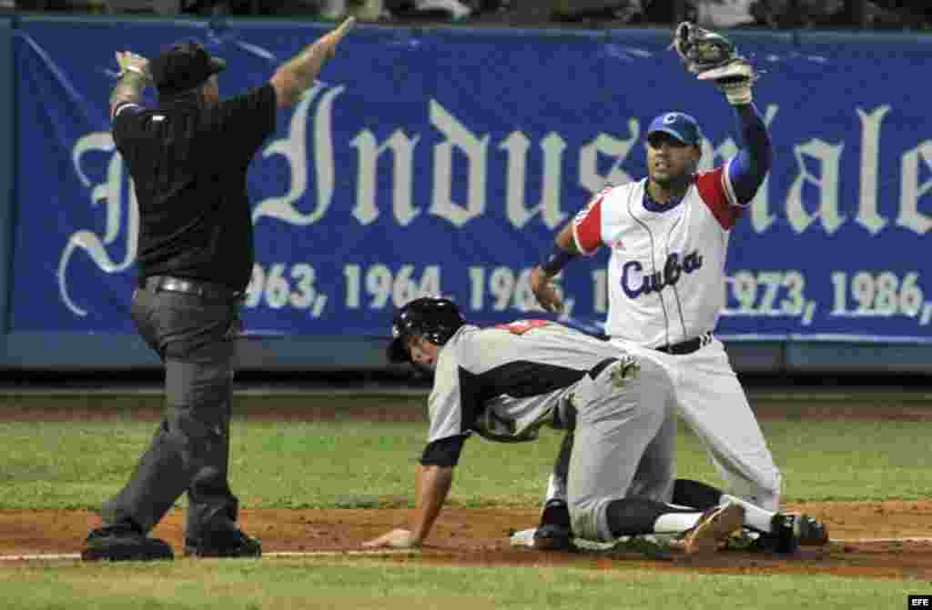 El jugador de Estados Unidos Kyler Farmer (c), llega quieto a 3ra base, junto al cubano Yuliesky Gourrier (d), el jueves 05 de julio del 2012, en el primer partido amistoso de los cinco que disputarán estas dos selecciones hasta el próximo lunes 9 de jul